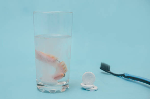 Cleaning a denture with a medical solution in tablets and a toothbrush