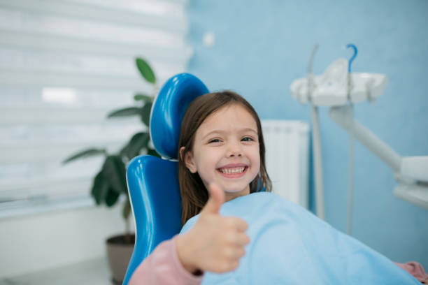 Portrait of a little happy girl sitting in a dentist chair